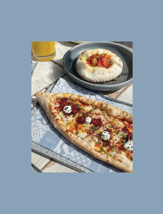 A pizza topped small balls of cheese and poppy seeds.