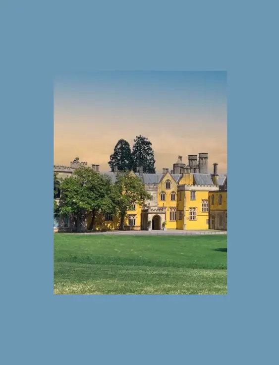 A wide shot of ashton court, the yellow house stands out sitting behind a green.