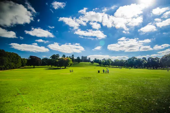 Image of Wollaton Hall on a sunny day with people walking