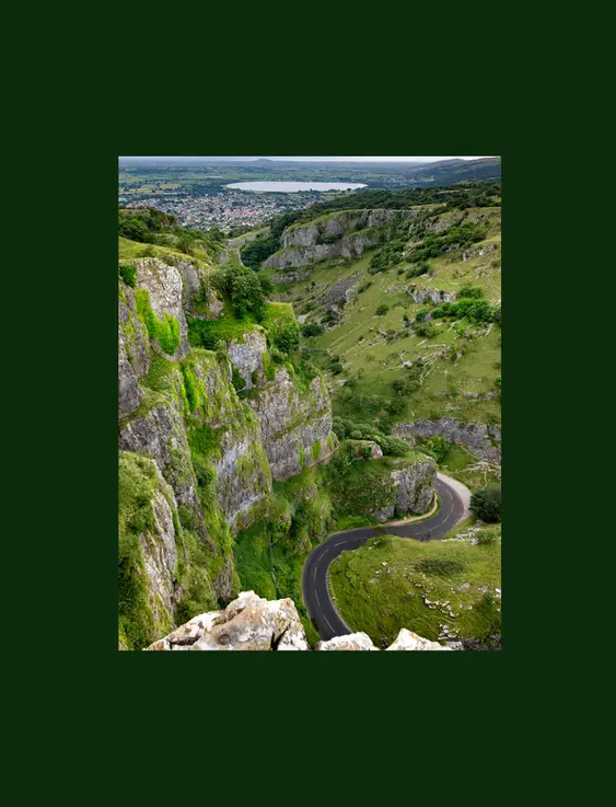 A view of the stunning cheddar gorge from the top, with a swooping road running through the cliffs..