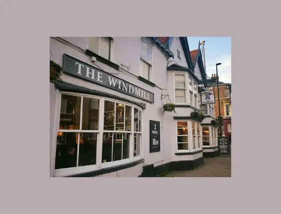 Front of a white pub called 'the windmill'.