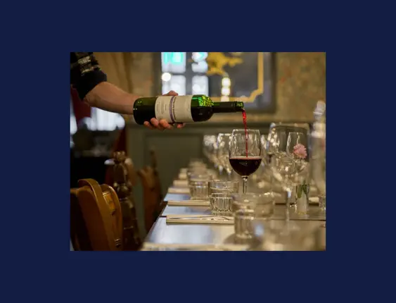 bottle of red win being poured into a glass
