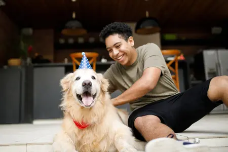Image of an owner with an older Golden Retriever dog on their birthday
