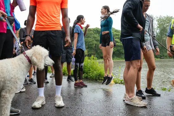 A low angle view of a group of people who are heading tot he starting line for a fun run that they are taking part in at Leazes Park in the North East of England, The race is inclusive of pets and people of all ages and abilities. They are all waiting at the starting line about to do a group
