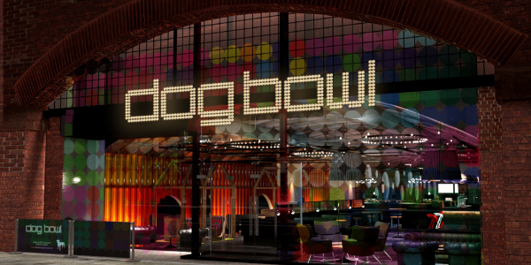 A neon-lit entrance to "dog bowl", an urban bowling alley, under a railway arch. The facade showcases a colourful, illuminated sign with interior glimpses of a modern lounge and bowling lanes.