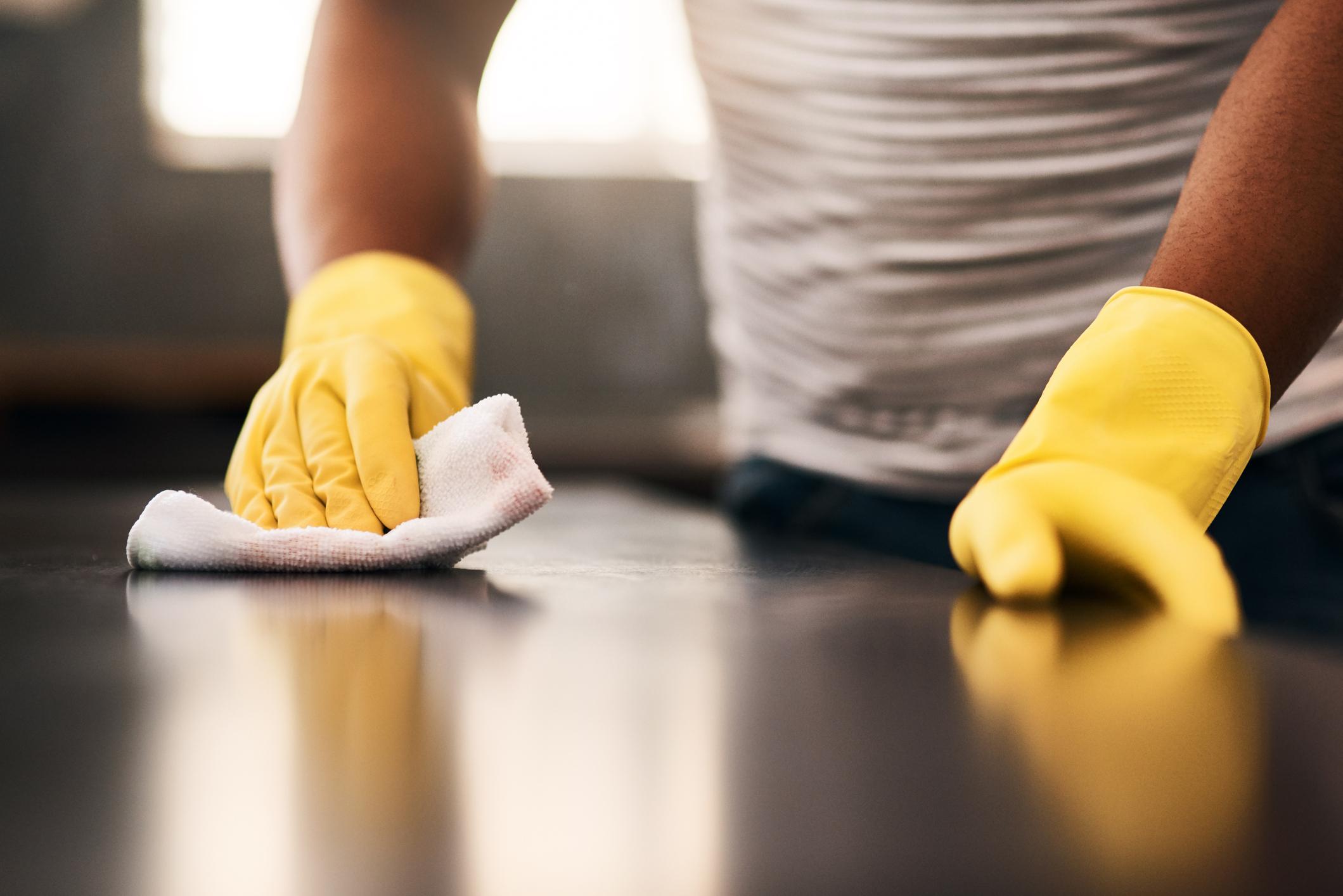 A person cleans with yellow gloves on
