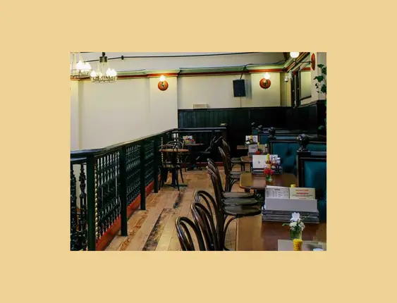 Spacious pub interior featuring a high arched ceiling and elegant balcony seating.