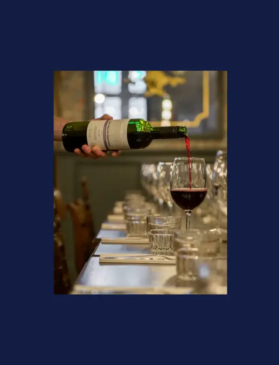 bottle of red win being poured into a glass