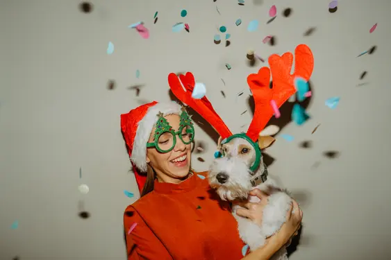 Image of an owner and a dog at a Christmas party