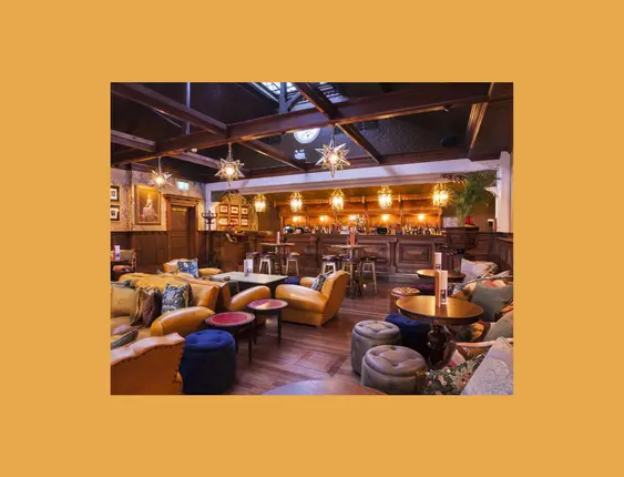 Opulent restaurant interior with plush seating, ornate lighting, and a classic wooden bar.