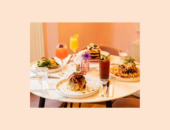 White round table with a range of brunches and cocktails on it.
