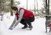 Image of a woman picking up poop in the snow