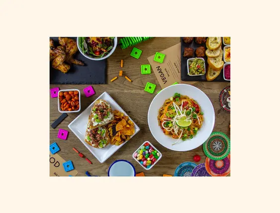 A mixture of food and board games on a table