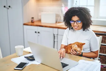 Woman with cat looking at laptop