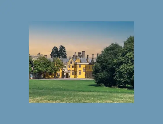 A wide shot of ashton court, the yellow house stands out sitting behind a green.