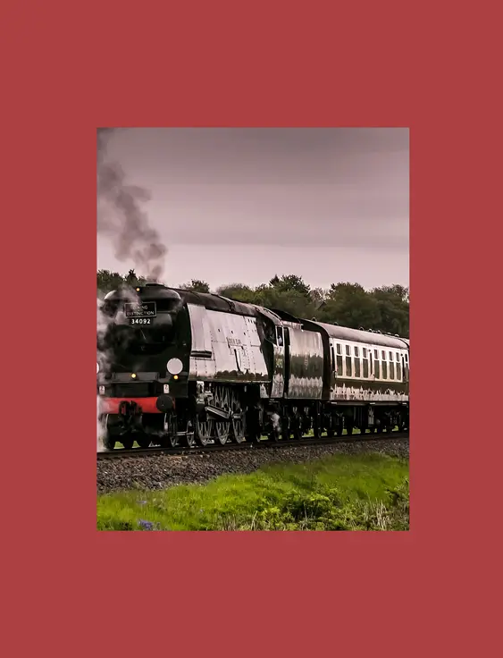 A vintage steam locomotive moves along the tracks, emitting a cloud of steam against a lush, tree-lined background.