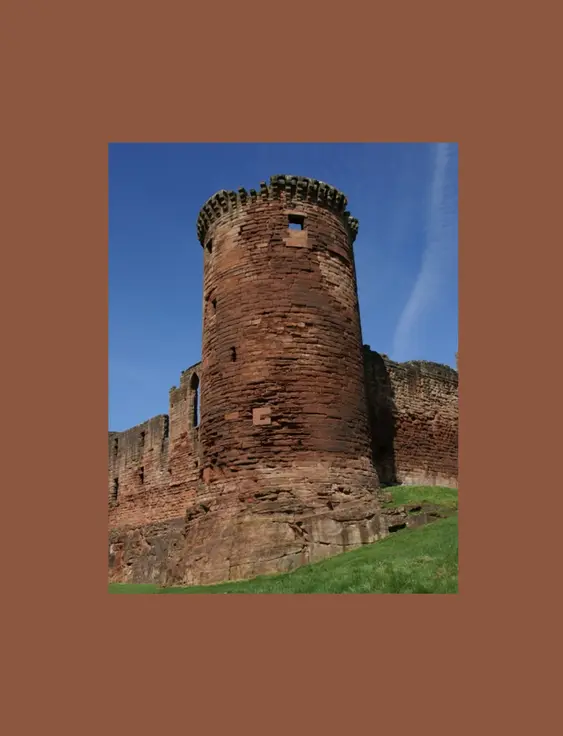 An ancient red sandstone castle with a prominent cylindrical tower stands under a blue sky, surrounded by vibrant green grass.