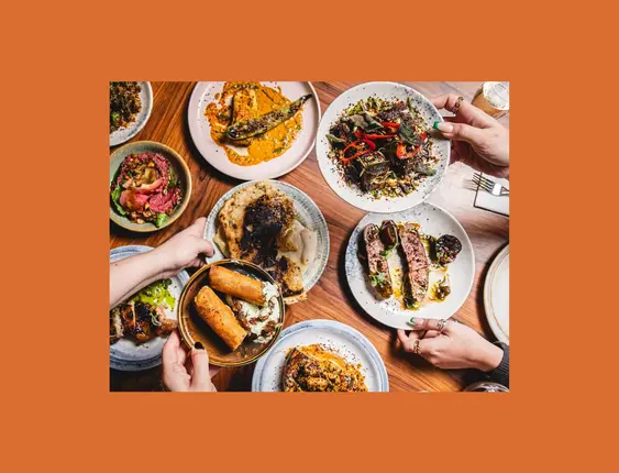 A table full of different wood fired small plates of food.