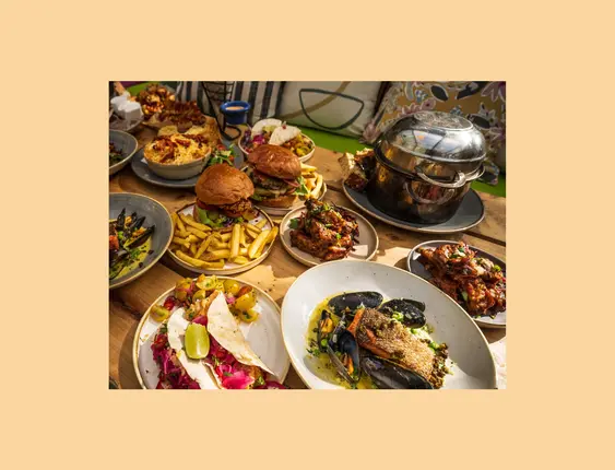 Sumptuous dining setup featuring a variety of dishes including burgers, mussels, and tacos.