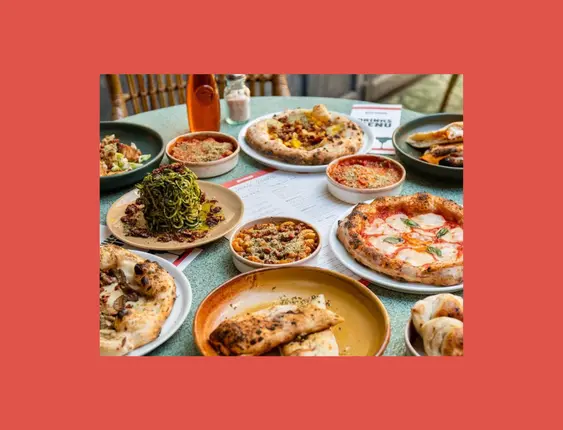 A green table with a mix of vegan Italian dishes on.
