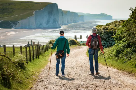 Two people walking on the Seven Sisters Walk, South Downs on a sunny day